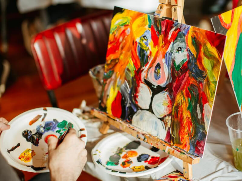 Close up on a stylised painting of a lion in colourful oils